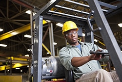 African American worker operating forklift
