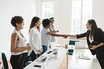 A woman shaking hands with the interviewer after a successful job interview