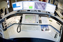 A dispatcher's desk with multiple screens and a phone