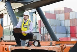 A transportation analyst standing on machinery on site