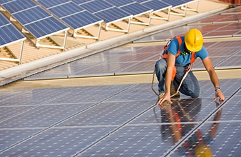 Solar Engineer Fixing a Solar Panel on a Rooftop