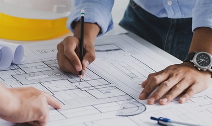 Engineers reviewing technical plans, supporting staffing needs for full-time, temp, and contract roles in engineering.