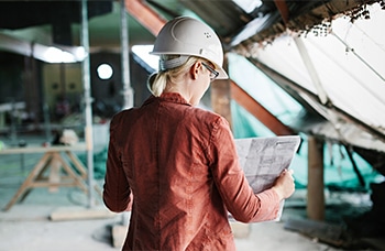 Female Architect Looking Over Blueprints