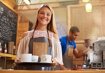 Happy Young Female Barista Working in a Temp Job