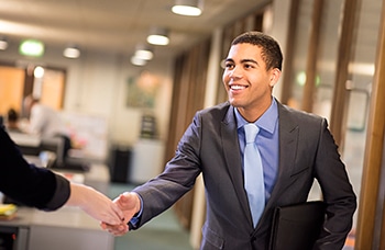 A young man shakes hands with his potential new boss