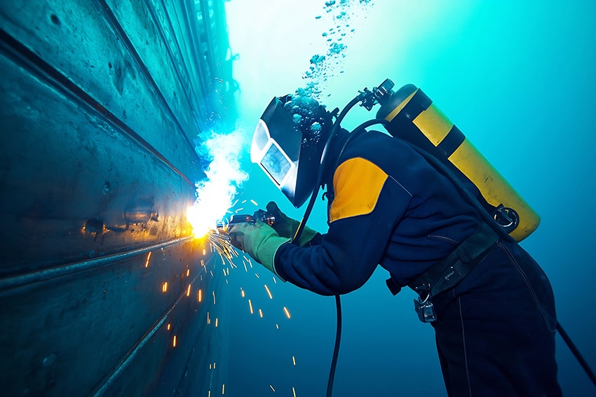 Diver conducting underwater welding on a submerged vessel in Canada’s offshore sector